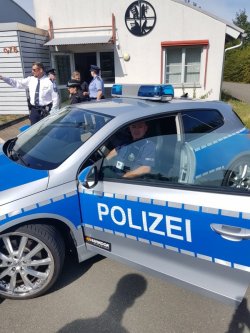 zdjęcie w kolorze - policjant w radiowozie niemieckiej Policji