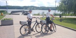 zdjęcie w kolorze - patrol rowerowy dzielnicowych na promenadzie jeziora Miejskiego